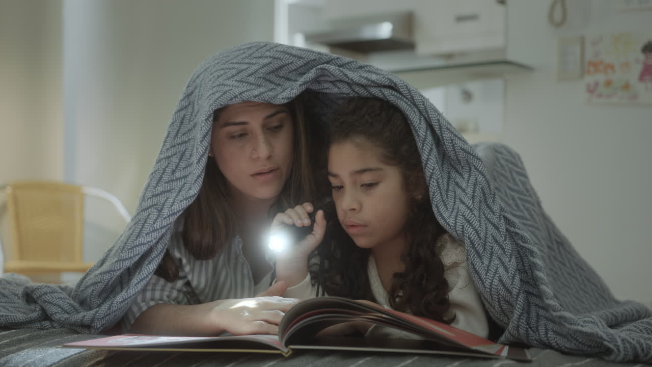 Mother and Little Daughter Reading Fairytale before Bedtime
