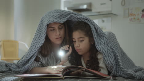 mother and little daughter reading fairytale before bedtime