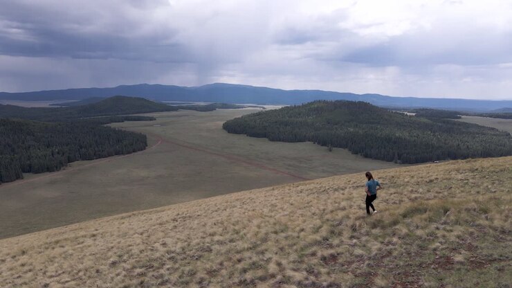Young Woman Hiking in Wilderness with Epic Scenic Backdrop - Aerial Drone Rotating
