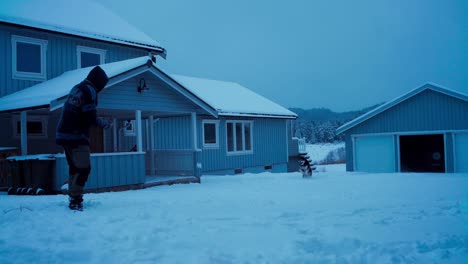 hombre y su perro mascota malamute de alaska jugando en la nieve - toma amplia