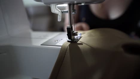 modern young woman sewing with machine, close up view