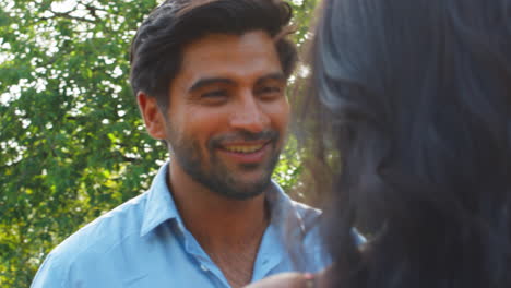 Close-Up-Of-Loving-Couple-Hugging-Outdoors-In-Garden-Or-Countryside-Against-Flaring-Sun