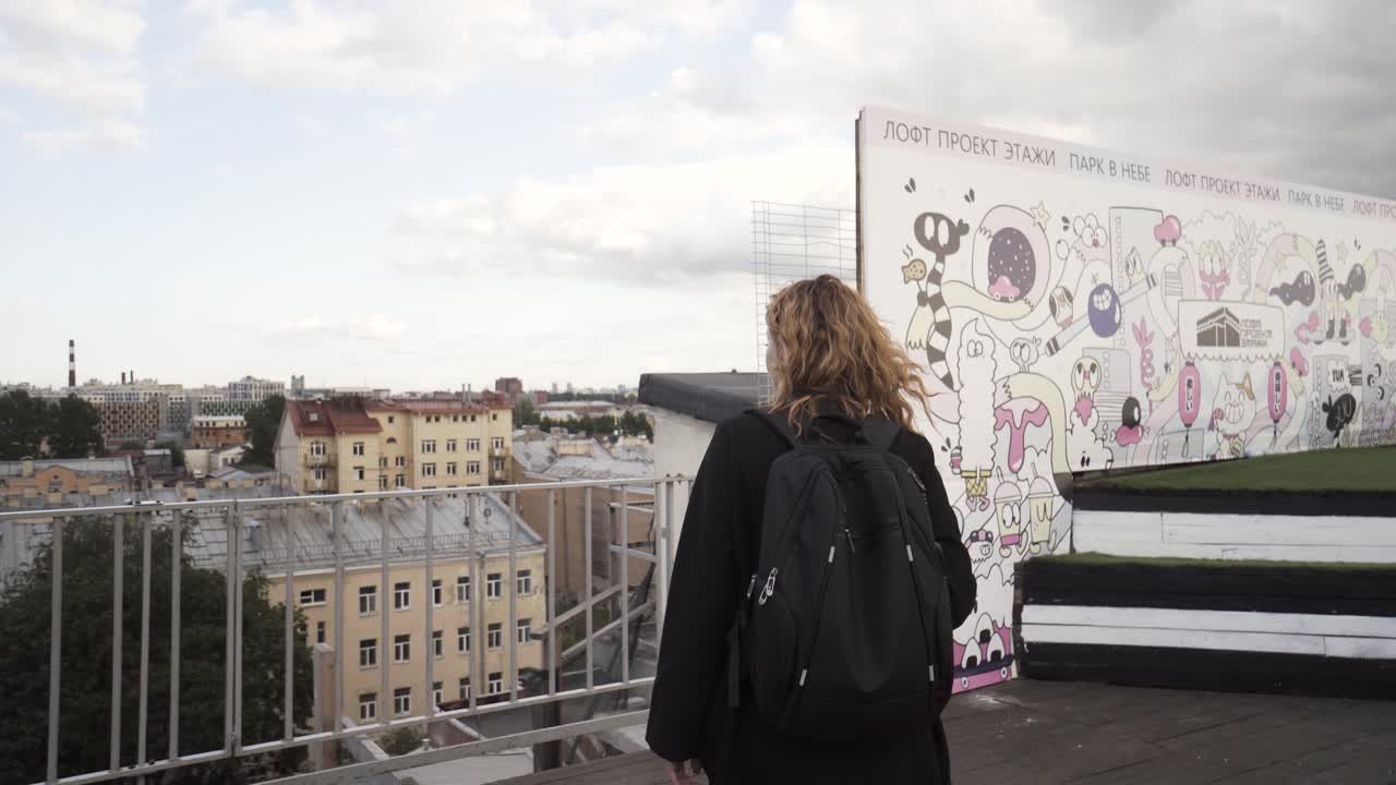 Donna su terrazza con vista sulla città