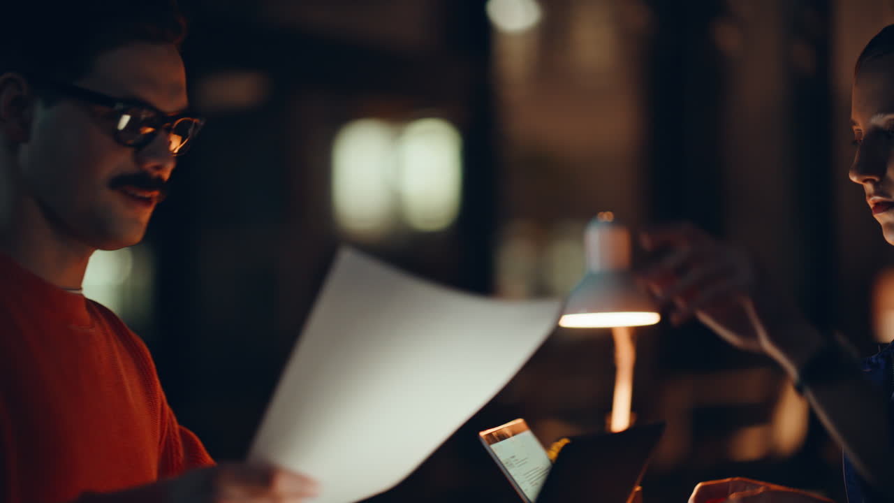 Smiling man talking colleague at night office workspace closeup. Two startupers