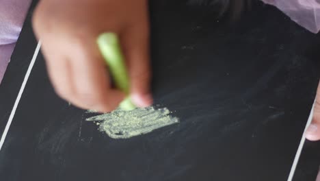 child drawing on a blackboard