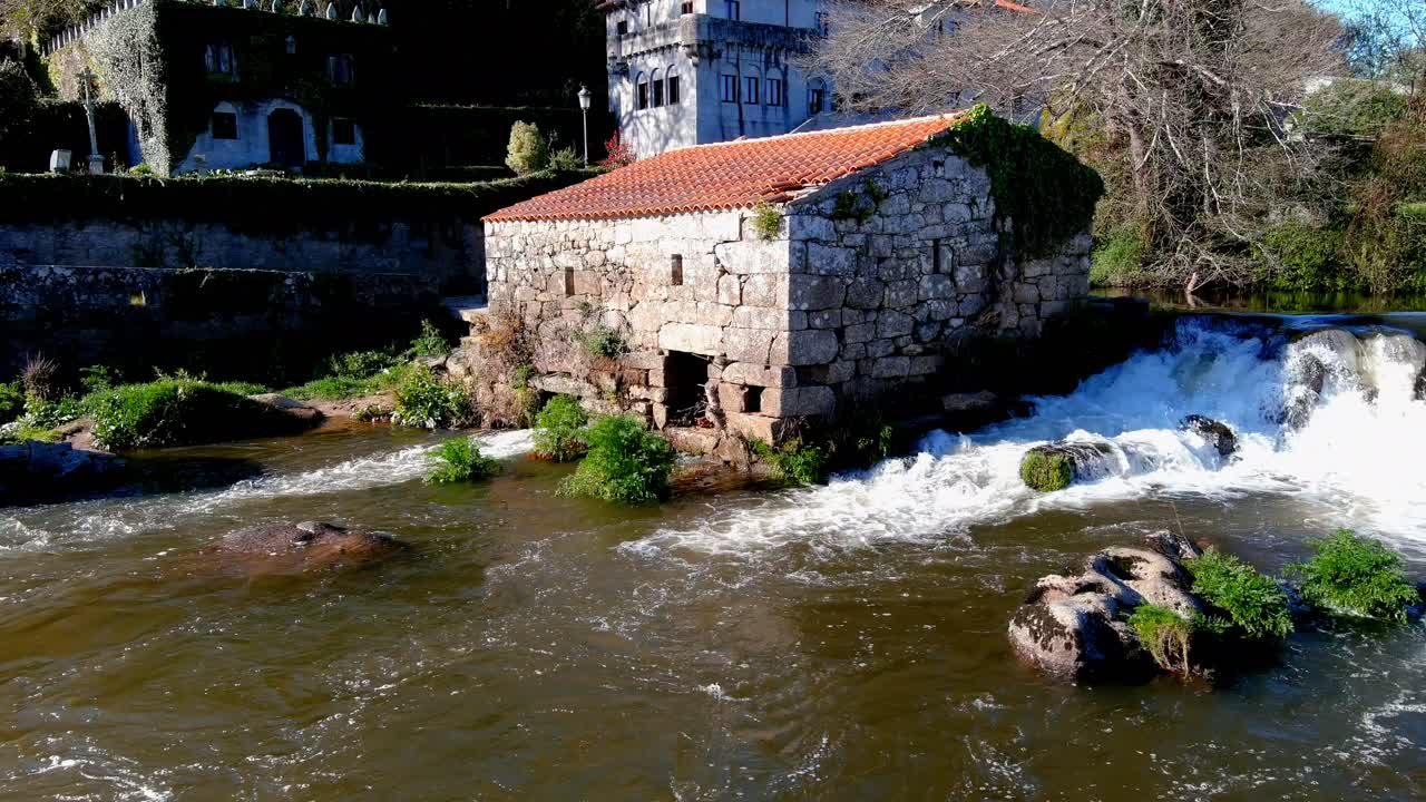 cerrar vista aérea del antiguo molino de agua en el río tambre con agua cayendo en cascada