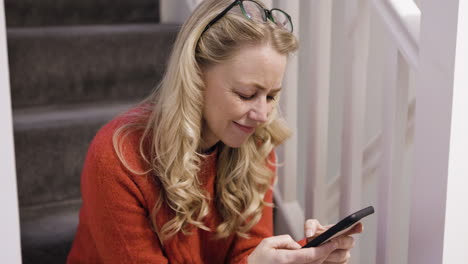 woman using phone on stairs