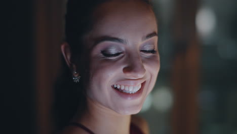 mujer pensativa mirando por la ventana usando un teléfono inteligente en el paisaje urbano nocturno plano de primer plano