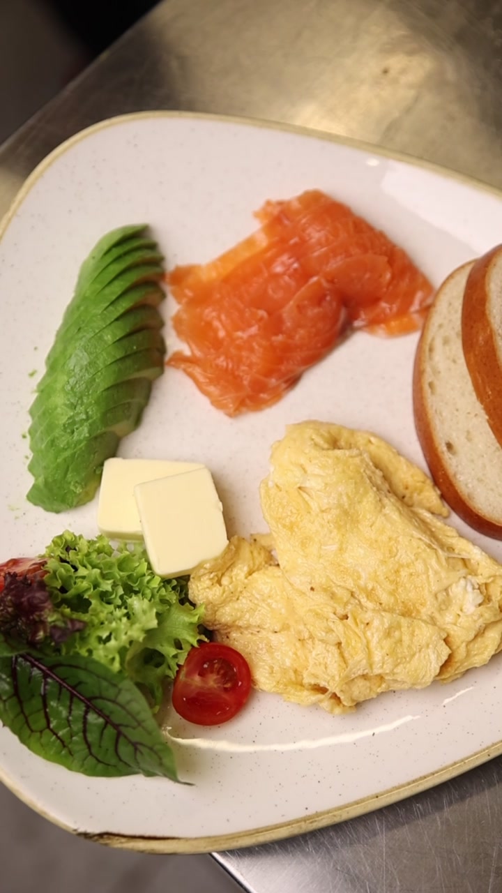Piatto per una colazione sana con avocado, salmone e uova strapazzate