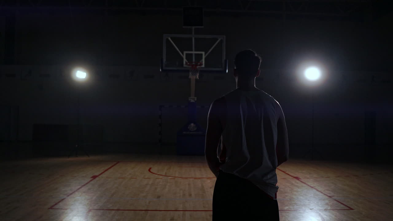 una toma de un jugador de baloncesto disparando detrás de los aros.