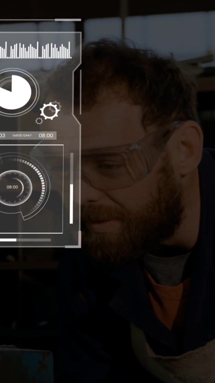 Video verticale: Uomo che sistema gli occhiali su una panca, attivando un HUD olografico che mostra grafici tecnici per la revisione.