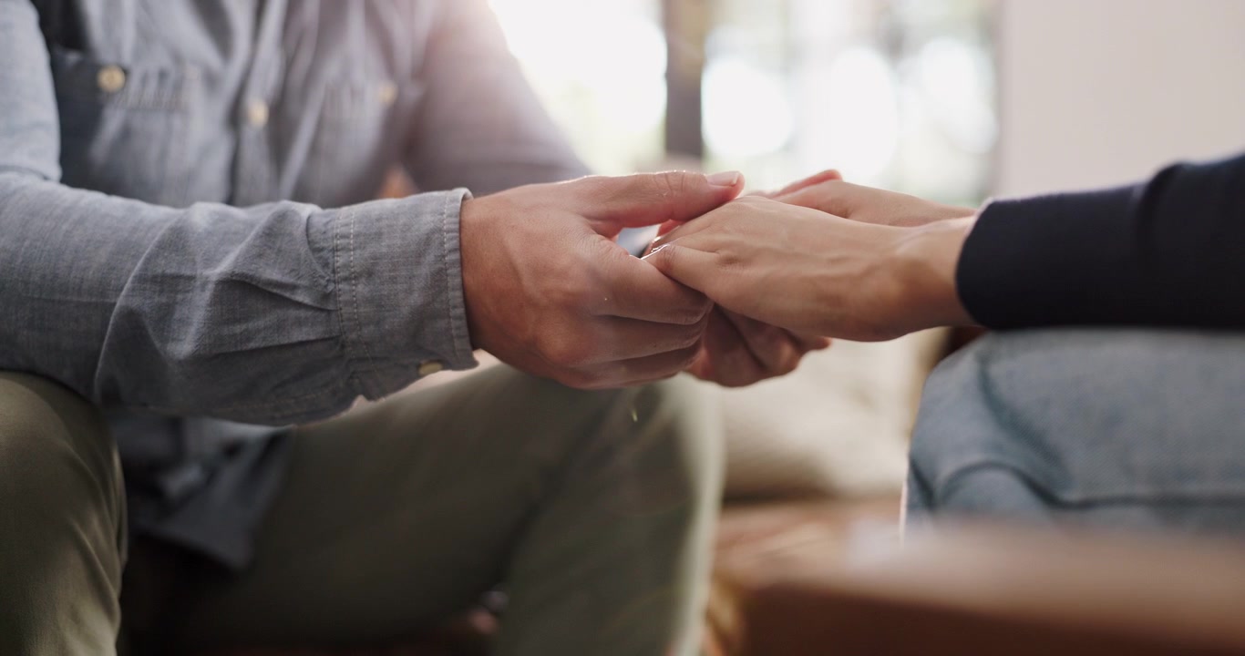 Primo piano di una coppia che si tiene per mano in segno di sostegno