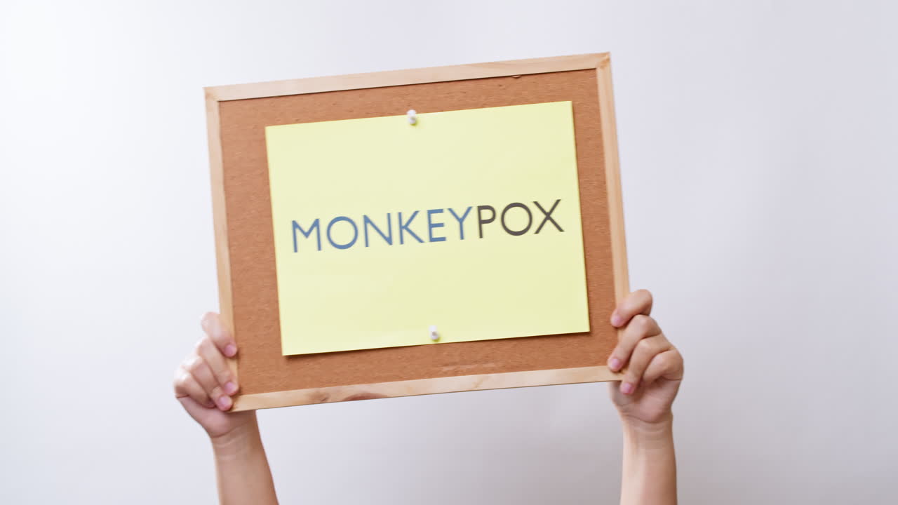 mano de mujer muestra una hoja de papel con la inscripción viruela del mono