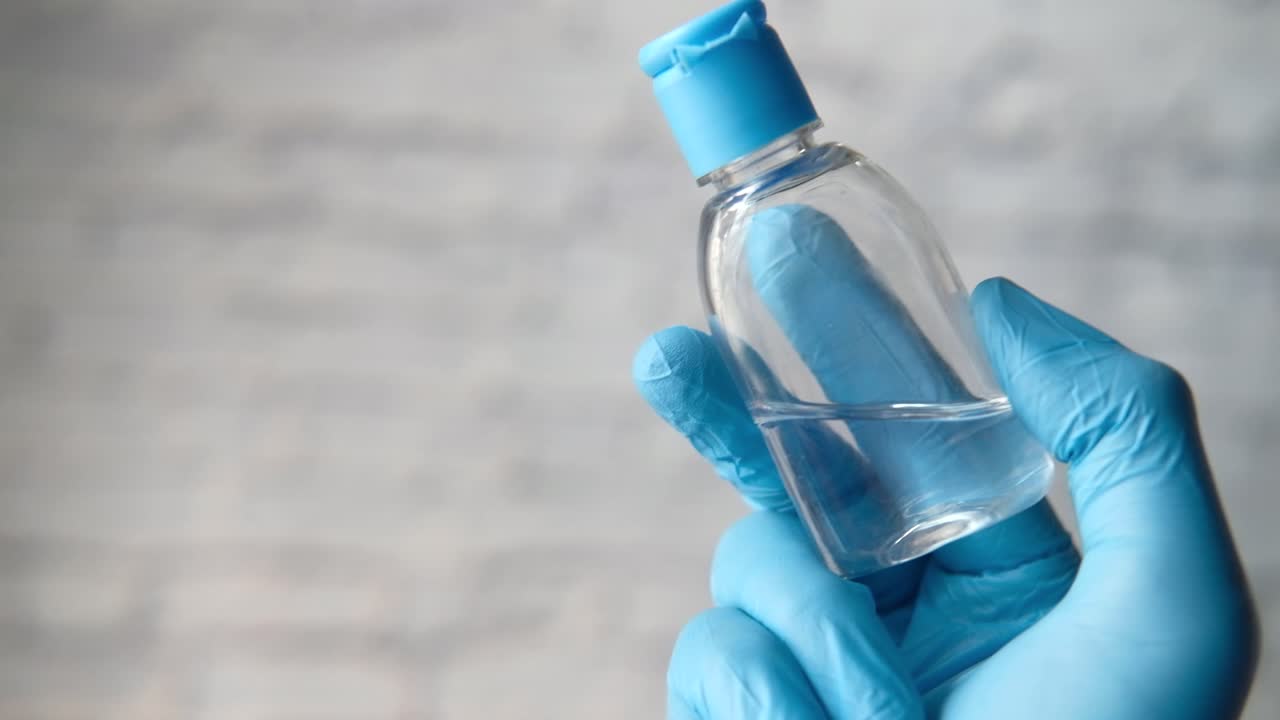 desinfectante para las manos en guantes azules