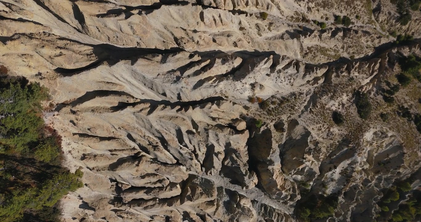 Circuito dell'Annapurna, Manang, Nepal, ripresa aerea in planata di spettacolari modelli di erosione del suolo e formazioni di argilla secca testurizzata lungo il Circuito dell'Annapurna