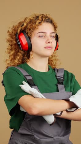 young woman worker with curly hair wearing safety gear