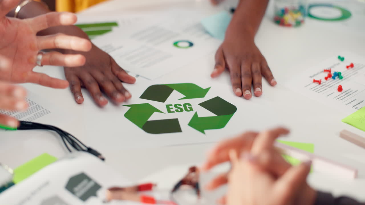 Hands Discussing ESG Recycling Symbol Document in a Business Meeting