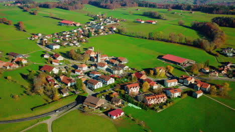 houses and green fields in the village of mezieres in fribourg, switzerland