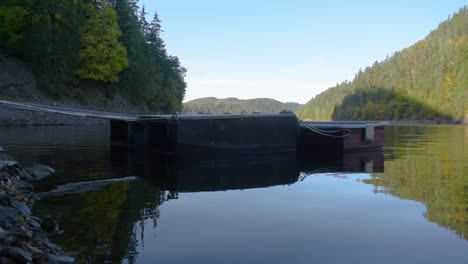 idyllic panoramic view of a big lake with mountains in the background and a wooden landing stage in the foreground-1