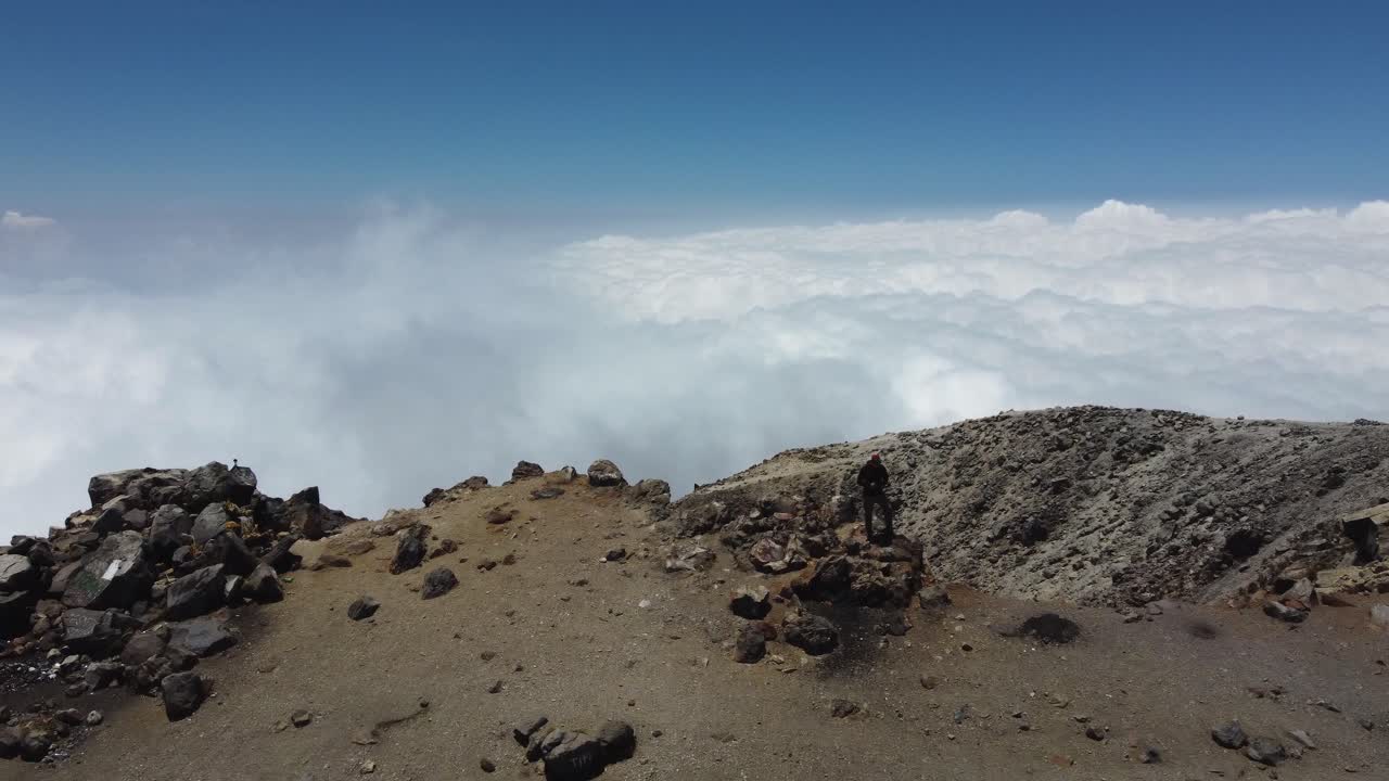 un avión vuela sobre un excursionista solitario en la cima del volcán tajumulco en guatemala mtns