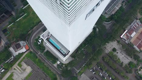 high-angle view of a modern skyscraper with a rooftop pool in a city