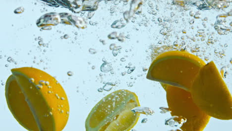 las cuñas de agua cayeron de cerca. piezas de cítricos de naranja flotando bajo un líquido transparente.