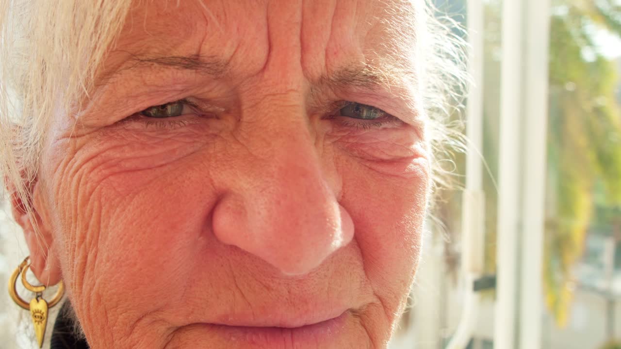 elderly lady woman close up camera sunny outdoor blond hair aging concept
