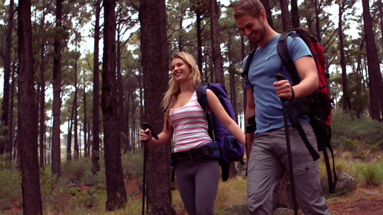una pareja caminando por un bosque.