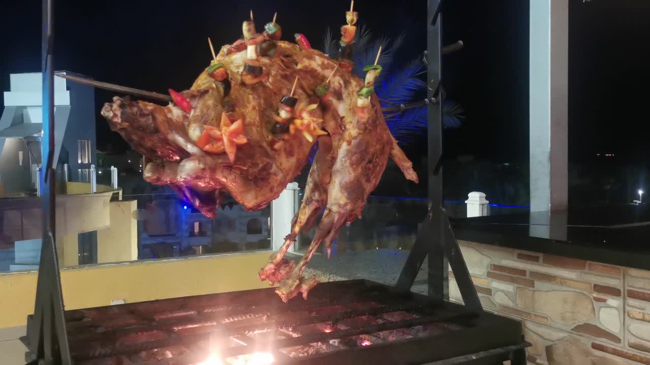 고기는 스피트 위의 그릴에  ⁇ 겨집니다. 양자는 레스토랑에서 열린 불 위에 스피트 위에  ⁇ 겨집니다.