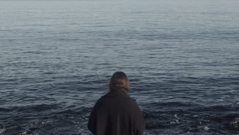 mysterious woman looking at the ocean in slow motion and 4k at 25fps