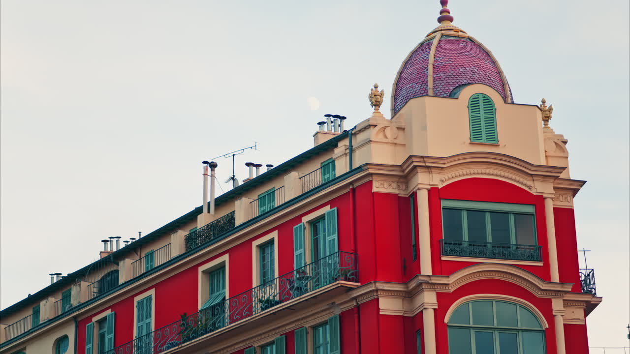 The facade of a Red building in Place Massena in daylight in Nice, France