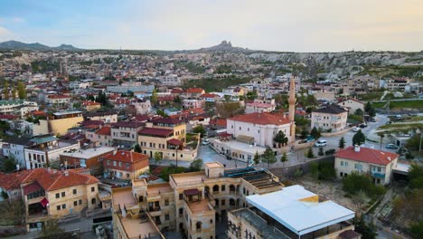 Beautiful-aerial-zoom-in-scenery,-beautiful-small-sunny-ancient-town-among-famous-rocks-in-summer-Cappadocia-Turkey