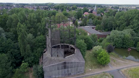 antigua torre de refrigeración en ruinas en un carril bici para la industria con la torre de la iglesia del pueblo de ilsede en alemania en el fondo