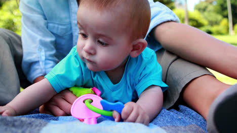 Mother-playing-with-her-cute-baby-son-on-picnic-blanket