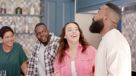 laughing and having fun, diverse friends enjoying time together in modern kitchen