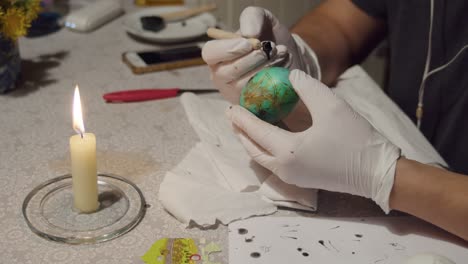 Female-hands-decorating-an-Easter-egg-using-the-traditional-Ukrainian-technique-Pysanka,-using-paints-and-wax