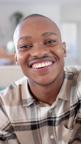 vertical video of happy african american man having video call, slow motion