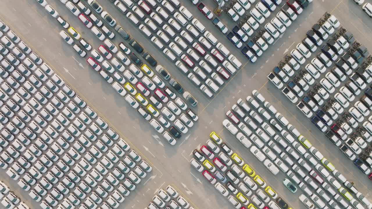 vista aérea de un gran estacionamiento centro de distribución de coches nuevos de un puerto marítimo moderno.