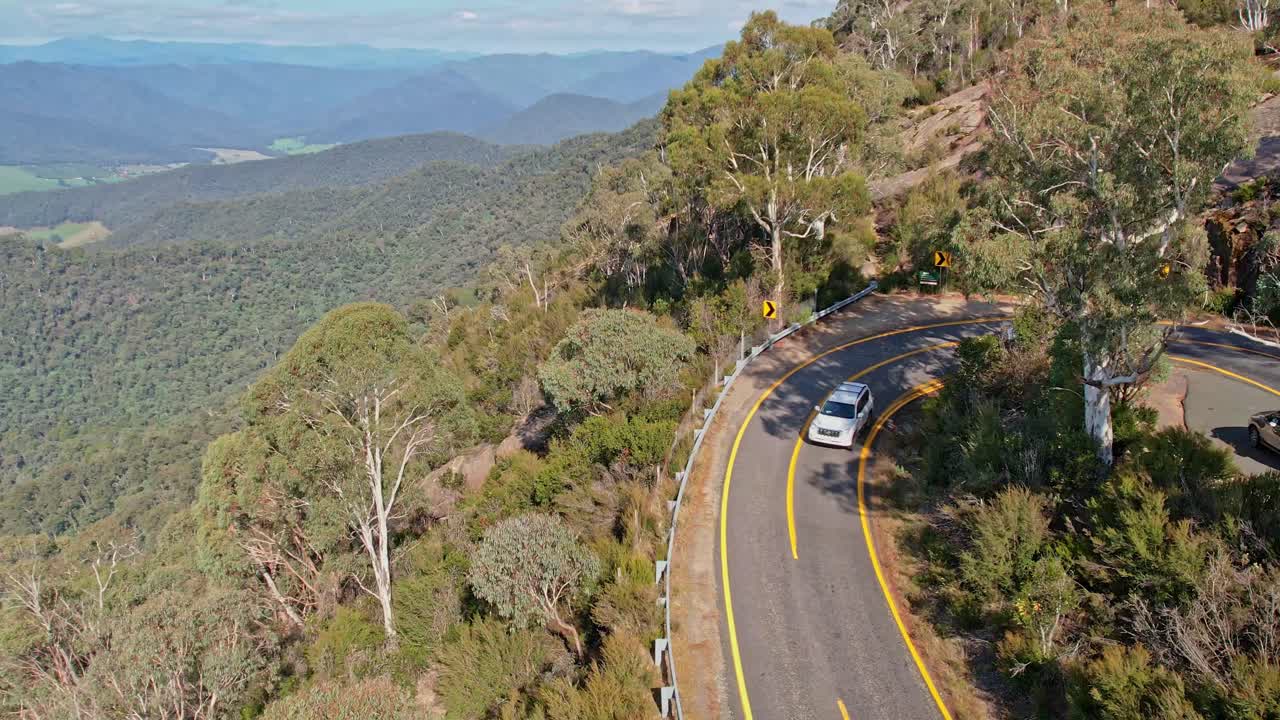 aérea de varios vehículos y turistas tomando fotos en el camino hacia abajo desde el monte búfalo en victoria, australia