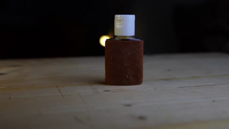 small brown natural product bottle with a white lid for soap or similar on a beautiful wooden plate rotates