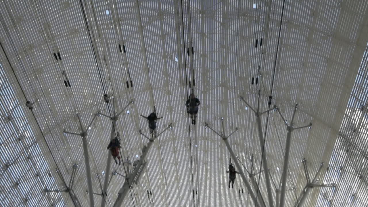 Four people flying past on the SlotZilla Zip Line over Fremont Street Experience, Las Vegas