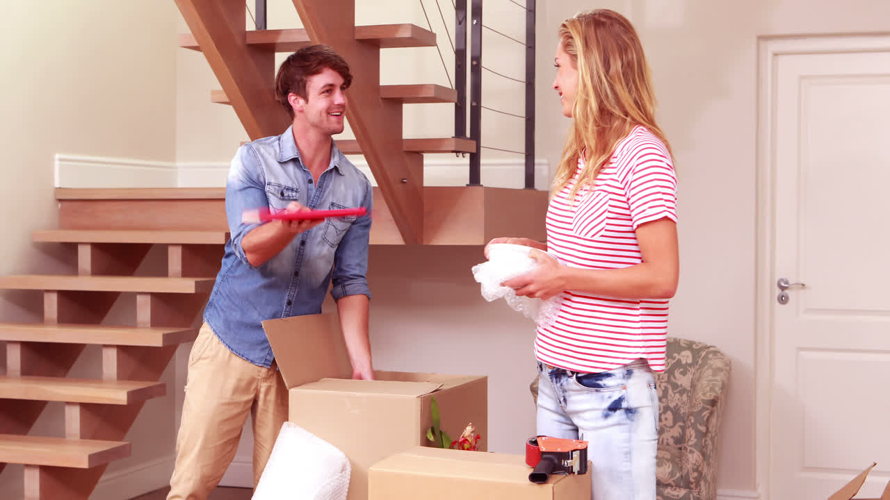 Young smiling couple unpacking boxes