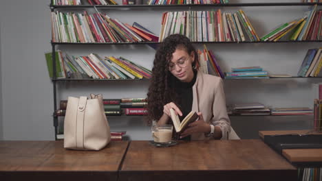 woman reading a book in a library cafe