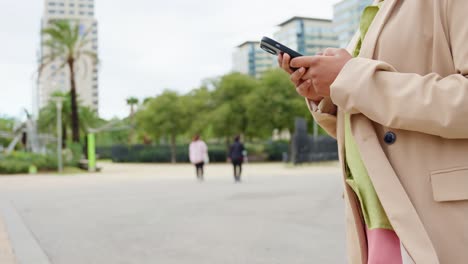 Woman using mobile phone in urban park