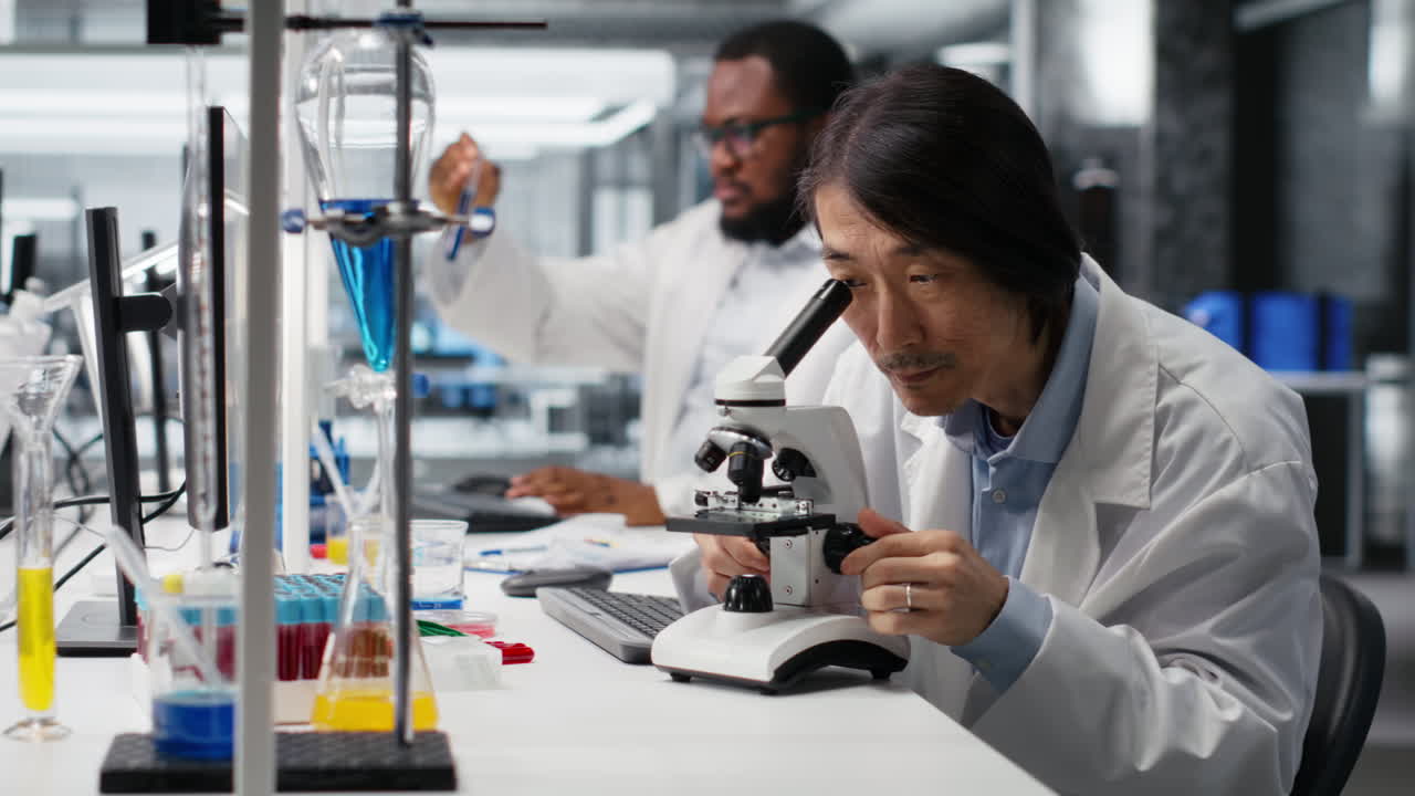 Vertical video Senior lab engineer inspecting specimen slide for microscopy study