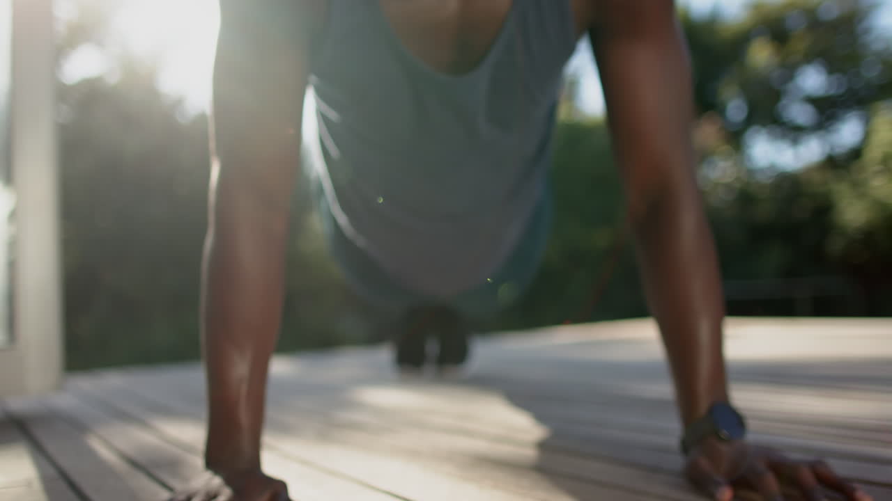 Doing push-ups, african american man exercising outdoors, focusing on fitness and strength training