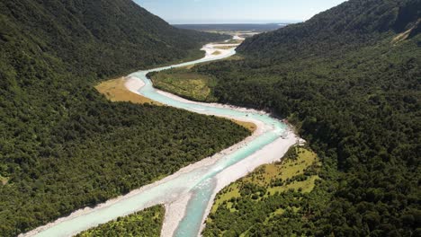 Confluence-of-two-glacial-rivers-and-wild-nature-scenery-of-Westland,-New-Zealand---aerial-pull-back-landscape