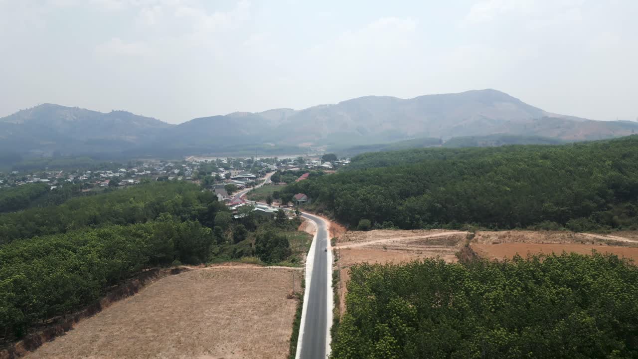 Aerial View of a Winding Road Through a Rural Village in a Mountainous Area