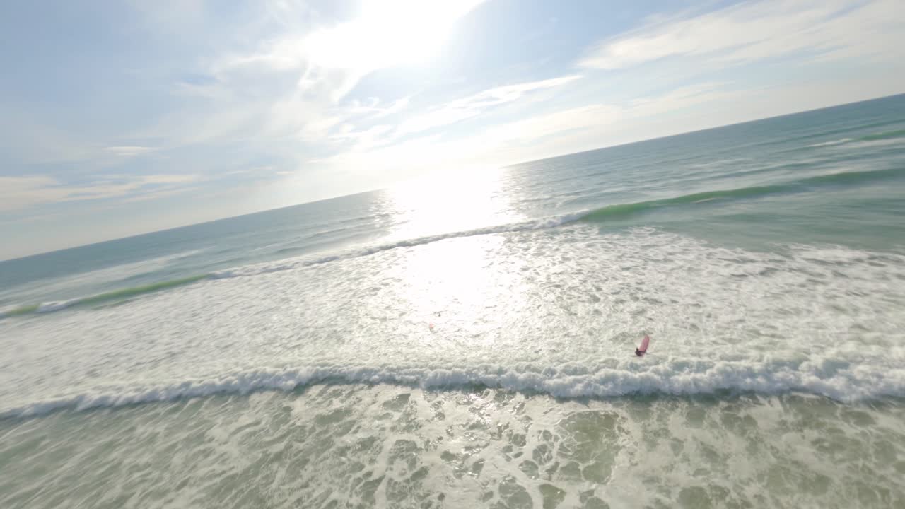 soustons 해변을 따라 해수에 진입하는 두 명의 서퍼 주위를 공전하는 공중 궤도