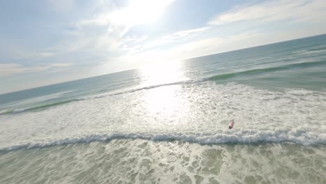 Aerial-orbiting-around-two-surfers-entering-in-ocean-waters-along-Soustons-beach